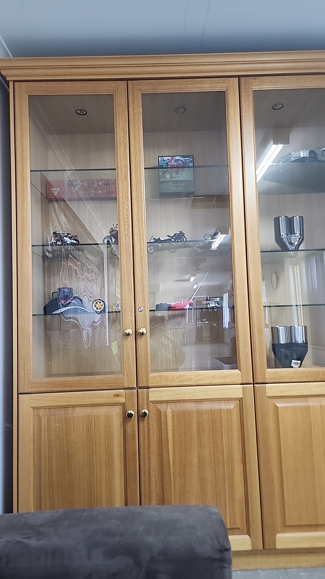 The display cabinet in the A2B Automotive waiting area, holding model race cars, motorbikes and polished chrome exhaust tips