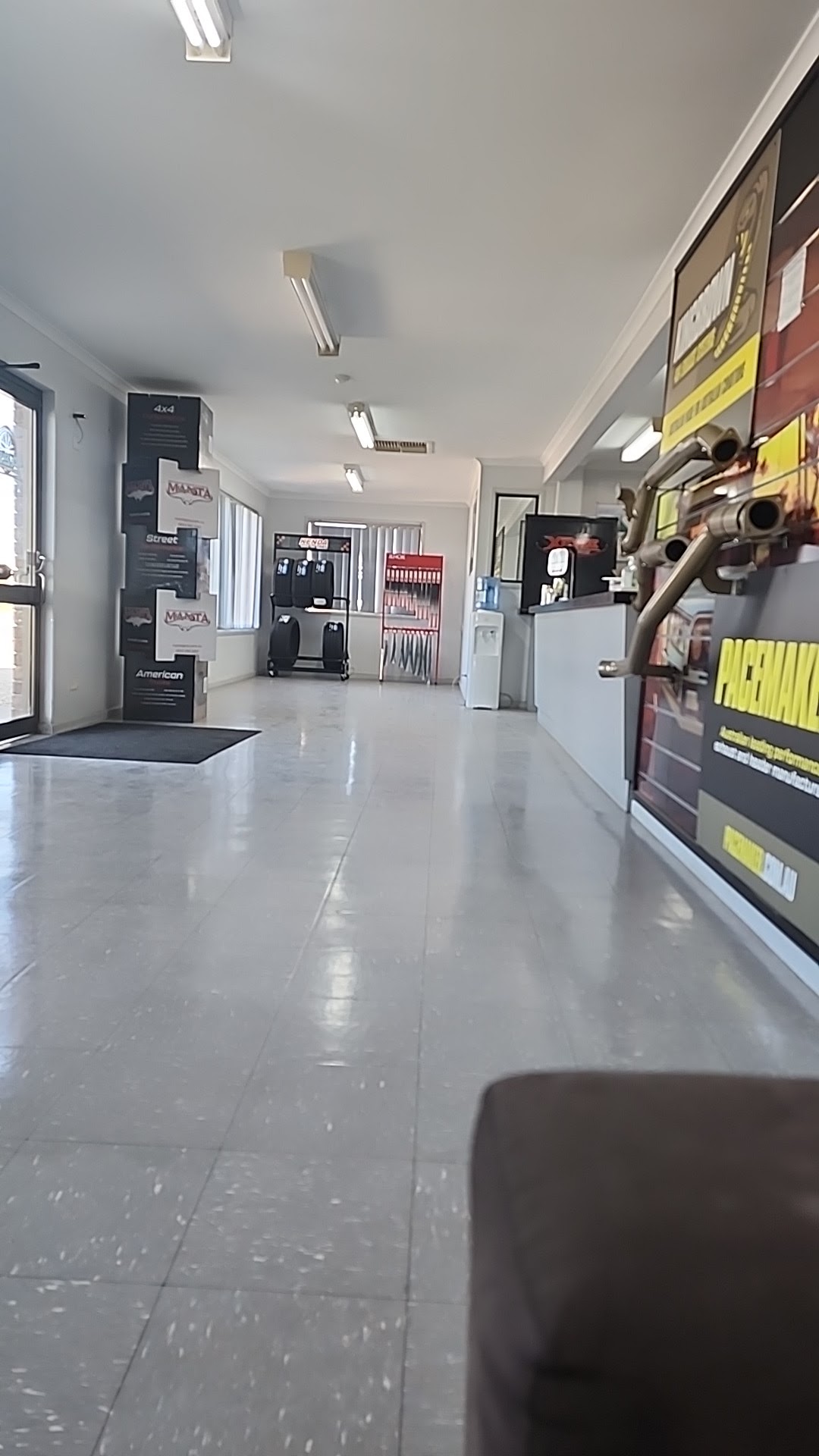 The front showroom at A2B Automotive, with Pacemaker Headers and Manta displays and a chrome extractor set mounted on the wall